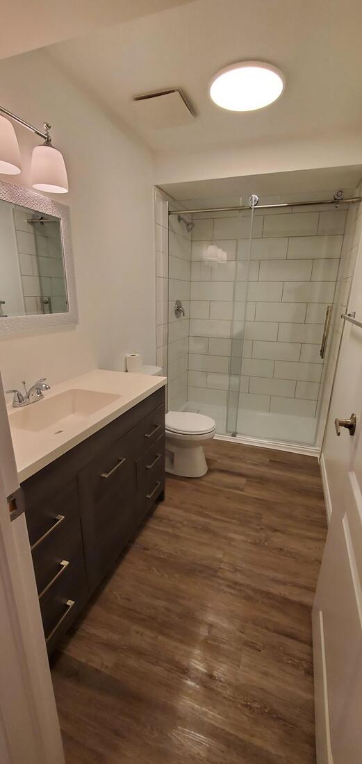 Basement bathroom. Tile shower with glass package